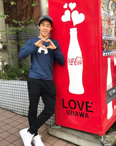 ネイサン・チェンがコカ・コーラの自販機の横でおにぎりTシャツを着てさりげなくPR